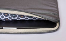 Load image into Gallery viewer, View inside the 15 inch grey MacBook sleeve showing black and white patterned lining fabric.
