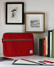 Cargar imagen en el visor de la galería, A laptop case ethically made in Nepal in shade of red canvas brightens up the desk of a small business owner while they are working on everyday communications using their MacBook Laptop.
