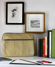Load image into Gallery viewer, A 15 inch MacBook Pro laptop case in sand shade sits on a white desk with books in the background including business start up 2017/18.
